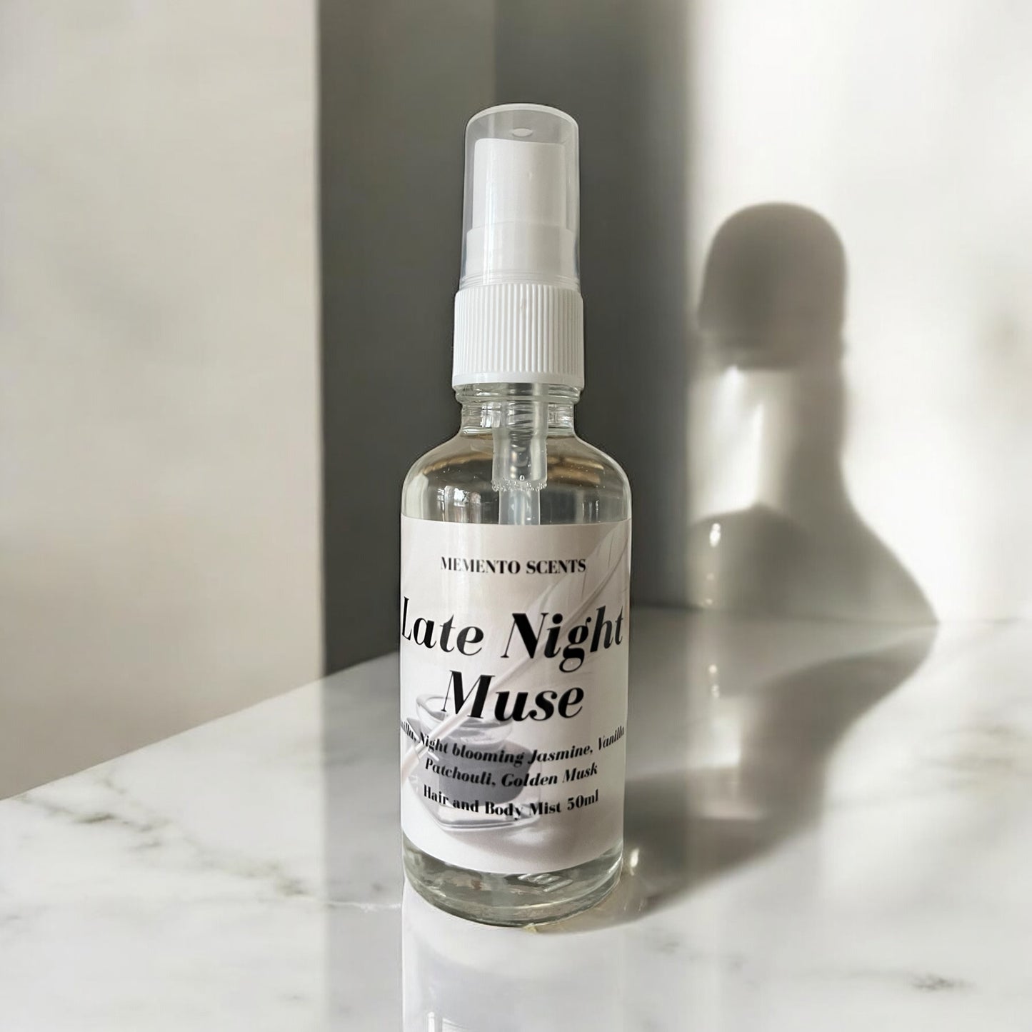 A bottle of late night muse hair and body mist with sheer vanilla, patchouli and night blooming jasmine