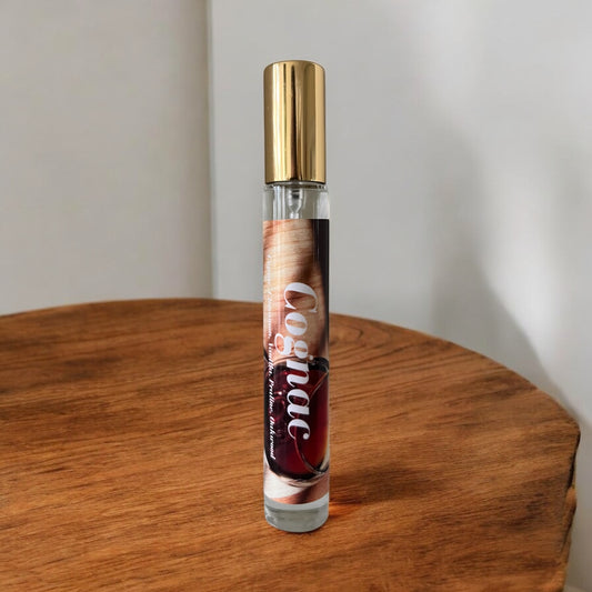 A bottle Of Cognac perfume on a wood table with notes of cognac, praline, vanilla and cinnamon