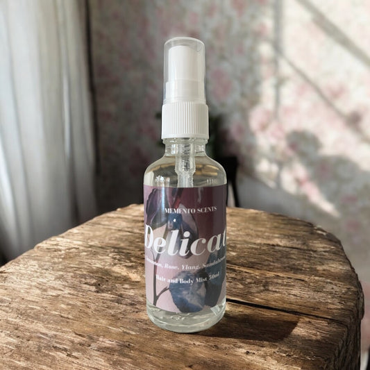 Delicate perfume bottle, set against soft floral and warm wood elements, with notes of cumin seed, cinnamon, rose, jasmine, ylang ylang, sandalwood, cedar, musk, and oud.