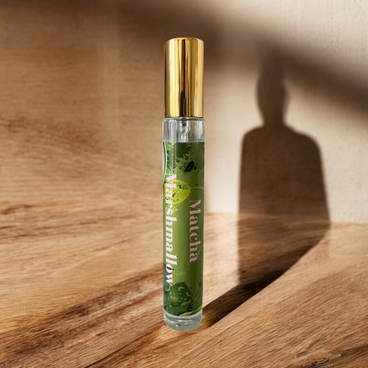 Matcha Marshmallow perfume bottle surrounded by soft ginger, matcha tea leaves, and creamy marshmallows, with notes of ginger, matcha, vanilla, and marshmallow.