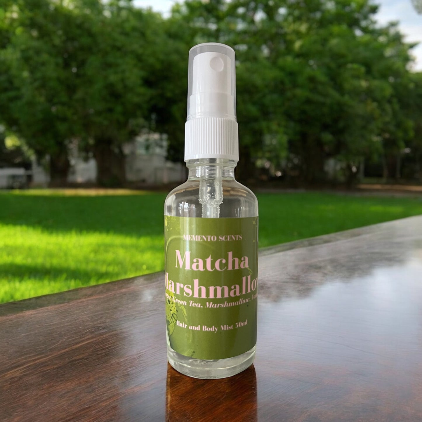 Matcha Marshmallow hair and body mist bottle surrounded by soft ginger, matcha tea leaves, and creamy marshmallows, with notes of ginger, matcha, vanilla, and marshmallow.