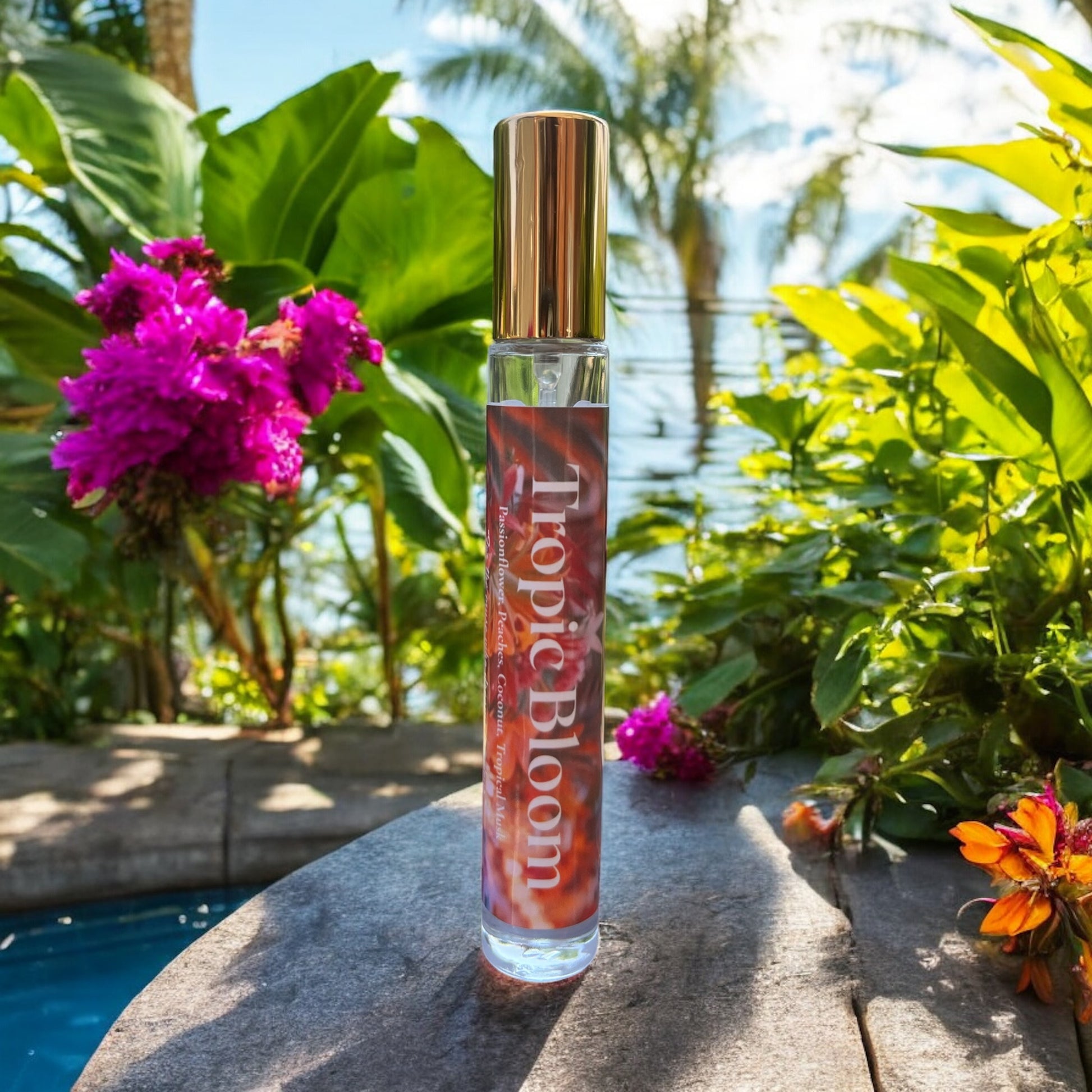 A bottle of Tropic Bloom perfume surrounded by lush tropical flowers with notes of peaches , passionflower, jasmine and coconut