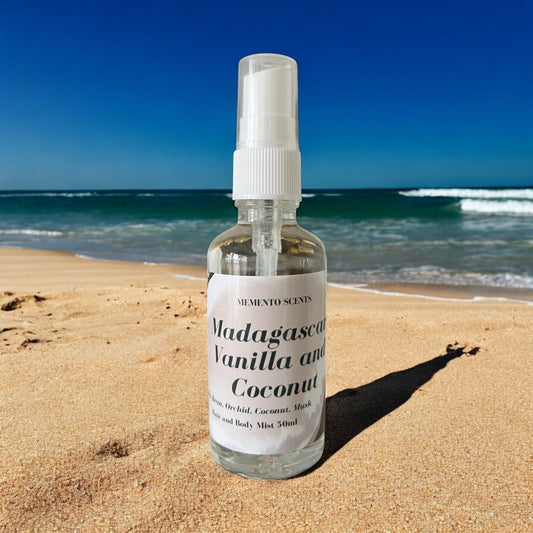 Madagascar Vanilla and Coconut Hair and Body mist bottle on the beach with notes of coconut, vanilla and musk