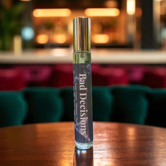 Perfume bottle labeled 'Bad Decisions' on a wooden table with a blurred background
