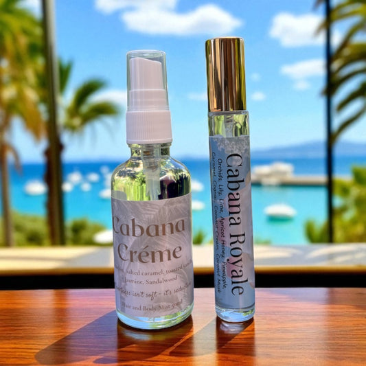 Two bottles of 'Cabana Creme' and 'Cabana Royale' on a table with a beach view in the background.