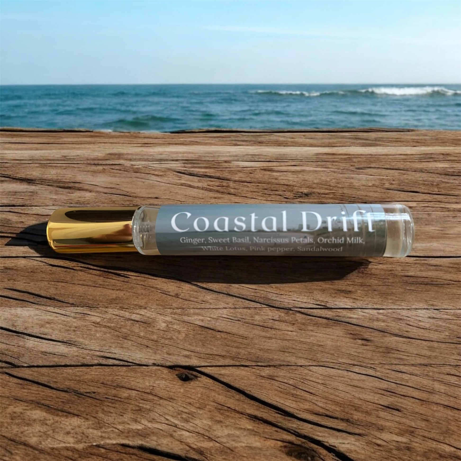 Spray bottle labeled 'Coastal Drift' on a wooden surface with ocean in the background