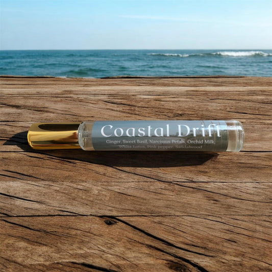 Spray bottle labeled 'Coastal Drift' on a wooden surface with ocean in the background