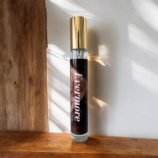 Perfume bottle labeled 'Evermore' on a wooden surface with sunlight casting shadows.