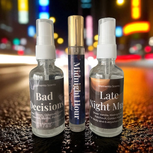 Three spray bottles labeled 'Bad Decisions', 'Midnight Hour', and 'Late Night Music' on a reflective surface with a blurred colorful background.