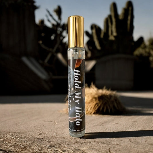 A bottle of hold my halo perfume surrounded cactus and the desert 