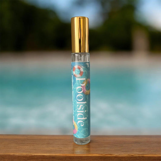 Glass spray bottle of parfum named Poolside on a wooden table with a pool in the background