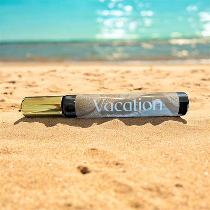 Spray parfum with 'Vacation' text on a sandy beach