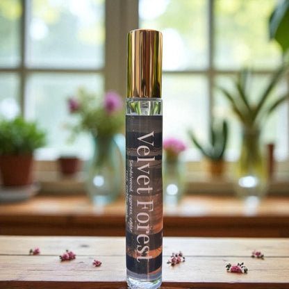 Perfume bottle labeled 'Velvet Forest' on a wooden surface with a blurred indoor background